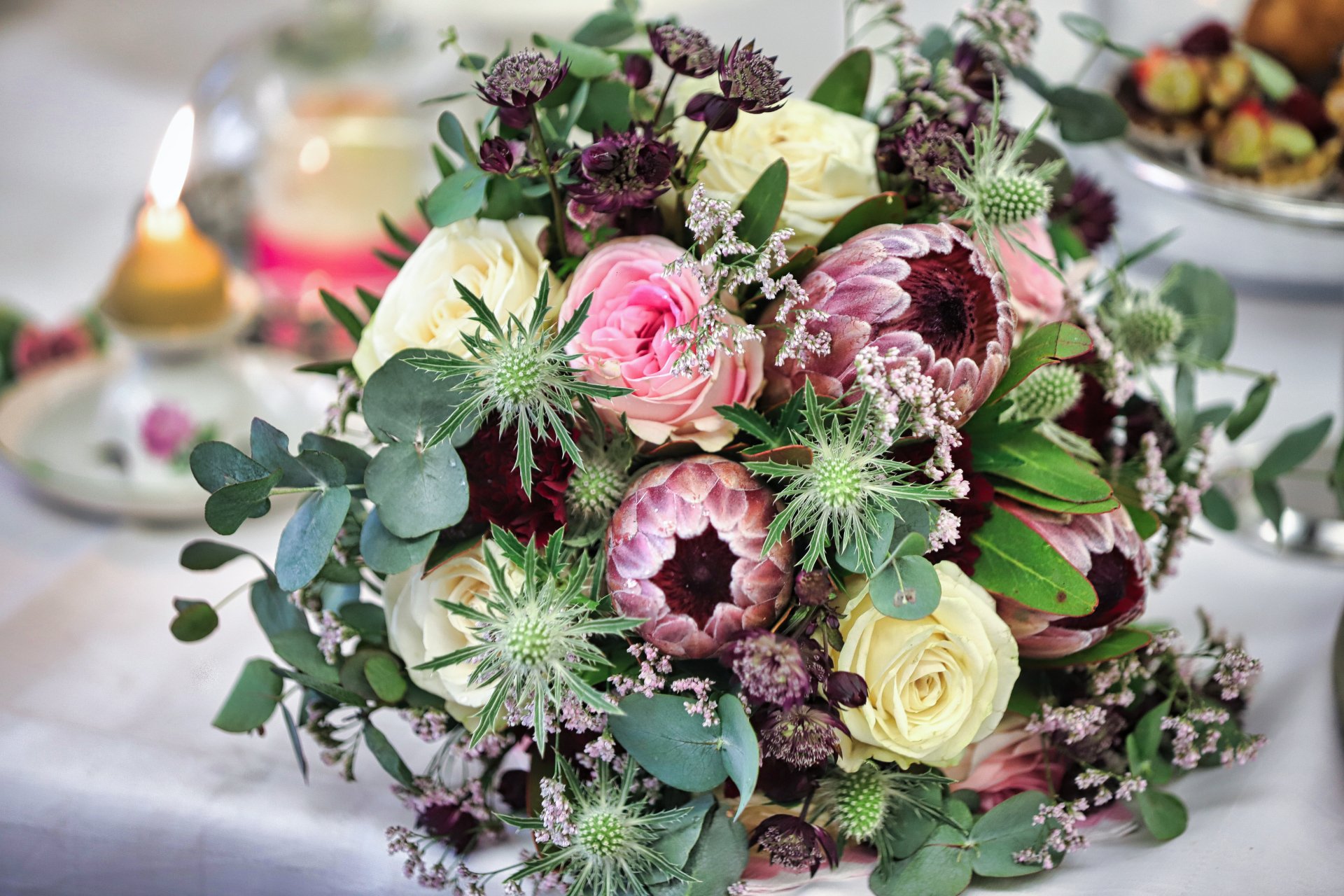 Hochzeit Tischgesteck mit Rosen und Naturmaterialien